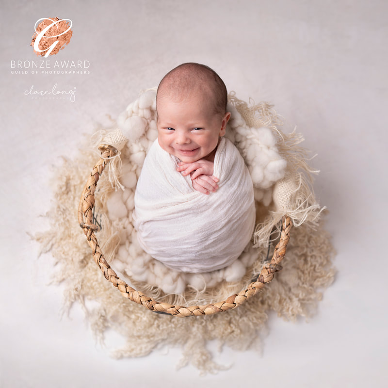Newborn baby smiling swaddled kent baby photography